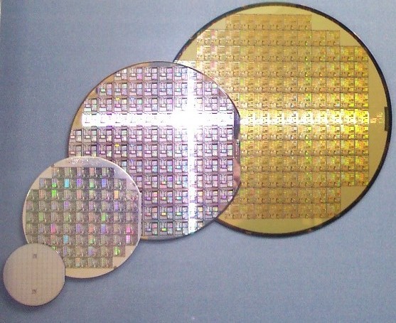 Silicon wafers in different sizes show the precision manufacturing base for all modern chips. Analog AI accelerators use the same substrate but require entirely different fabrication challenges to maintain conductance precision across billions of devices. Credit: Wikimedia Commons